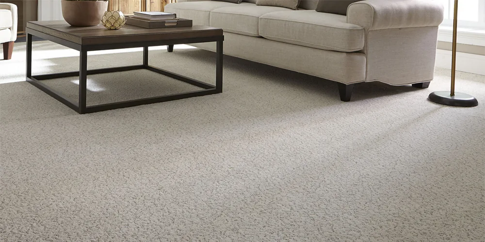 Beige wall to wall carpet under sofa and coffee table