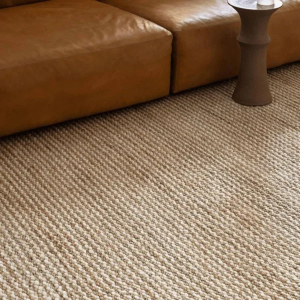 Chunky jute wall to wall carpet under leather couch