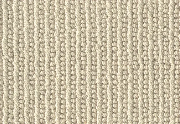 Close-up of a neutral beige wool loop pile carpet texture.