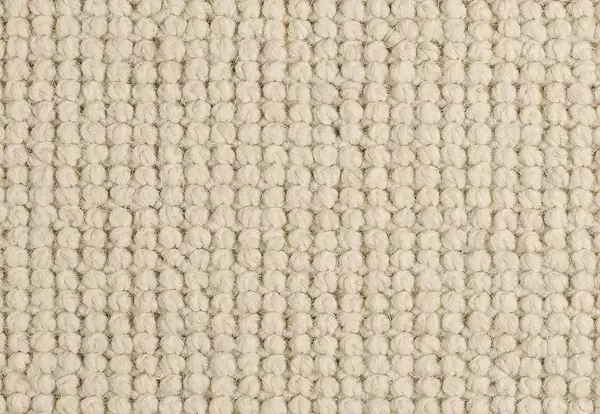 Close-up texture of a chunky off-white wool loop pile carpet.