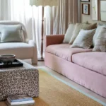 Cozy living room with a beige jute rug, pink sofa, and patterned pillows.