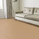 Modern living room with a cream sofa, floor lamp, curtains, and tan carpet.