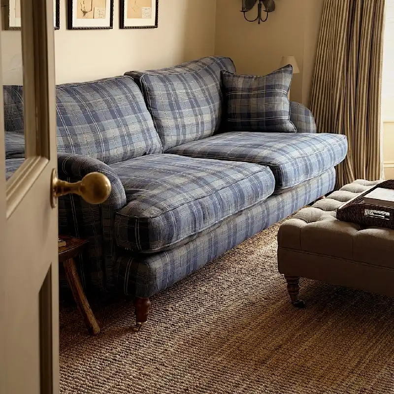 natural jute carpet flooring displayed beneath a blue plaid fabric sofa.